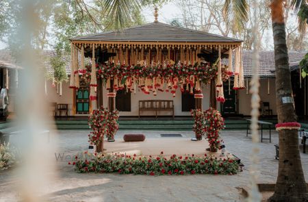 Beautiful south indian mandap decor with white and red florals for an outdoor wedding