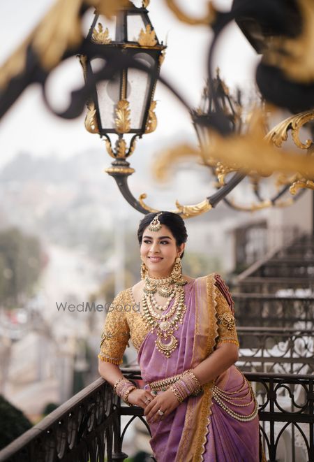 Lovely bridal portrait with the bride in a lavender and gold saree and stunning south indian jewels